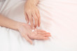 © BoszyArtis - Woman applying moisturizing cream/lotion on hands, Top View, beauty concept.