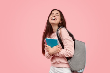 Excited student laughing and hugging notebooks