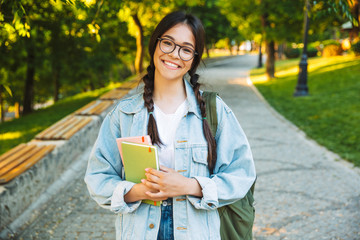 Canvas Print - Happy young teenage student girl carrying backpack