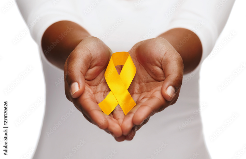 healthcare, charity and medicine concept - close up of woman cupped hands holding yellow gold childhood cancer awareness ribbon - obrazy, fototapety, plakaty 