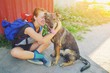 © raisondtre - Portrait young hipster woman with backpack kissing dog outdoors Happy pet and attractive girl playing fun Positive human emotions, facial expression, feelings Friendship hug between owner and animal.