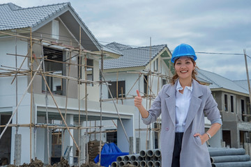 Women, Asian electrical engineers stand confidence and experience in real estate development.