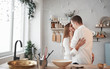 © standret - Cozy home atmosphere. Happy couple kissing in the kitchen. Having nice weekend together