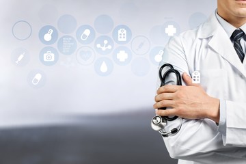 Wall Mural - Male doctor with stethoscope on blurred hospital background