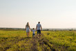 © ylyastik - Summertime in the countryside. Silhouettes of the family on the trip at the sunset. Happy pregnant family with little son spending time together in sunny field