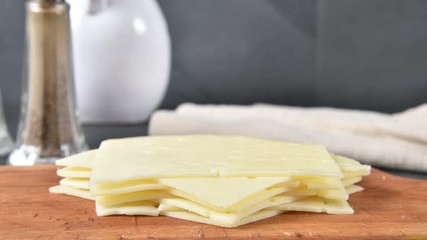 Canvas Print - Slices of swiss cheese stacking on a cutting board, stop motion animation