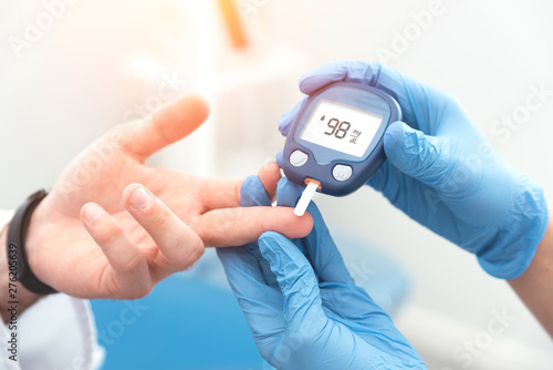 Cuadros en Lienzo Doctor checking blood sugar level with glucometer