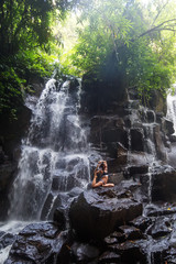 Sticker - Woman practices yoga near waterfall in Bali, Indonesia