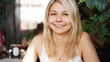 © brillianata - Portrait of smiling blonde sitting at coffee shop near green plants