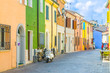 Typical italian old buildings with colorful multicolored walls and traditional houses and motorcycle bike scooter parked on cobblestone street in historical city centre Rimini, Emilia-Romagna, Italy
