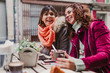 © Eva - Three women friends having coffee in a terrace in Oporto, Portugal. Having a fun conversation. Lifestyle, tourism and holidays