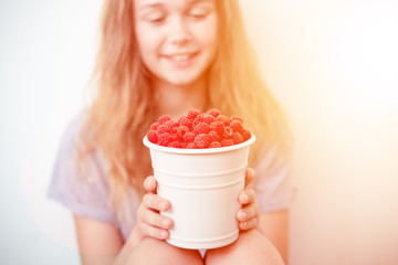 Wall Mural - Girl holding a metal bucket with fresh ripe raspberries. Toned