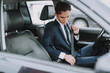 © Yakobchuk Olena - Young man in black suit using seat belt in his auto