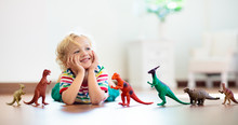 Child Playing With Toy Dinosaurs. Kids Toys.