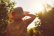 © Mihail - back view of adult woman in summer hat raise hands to the sun shine