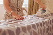 © Mihail - adult woman doing housewife work ironing textile