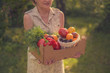 © Mihail - adult woman holding a crate with fresh new season harvest in the garden