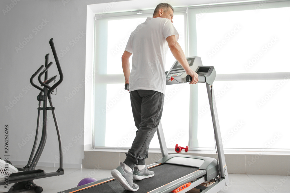 Mature man training in rehabilitation center