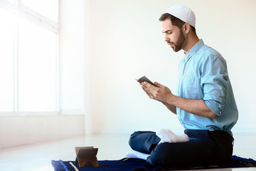 Wall Mural - Young Muslim man praying indoors