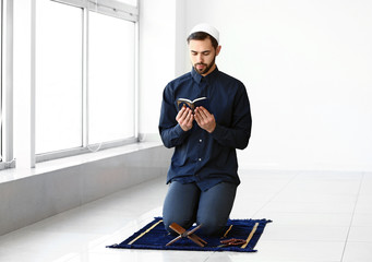 Wall Mural - Young Muslim man praying indoors