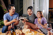 © DragonImages - Joyful young Asian people sitting in backyard and enjoying wine with delicious pizzaa