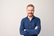 © DragonImages - Portrait of happy confident young man folding arms and looking at camera