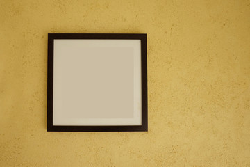 Empty picture frames on vintage yellow walls.