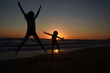 © Ivan - Silhouette of mother and son playing on the beach at the sunset.  Concept of family life and joy, summer vacations