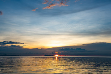 Wall Mural - Beautiful beach sunset with blue sea and golden light sky  cloud background