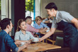 © Kzenon - Waiter serving coffee to young woman in the cafe