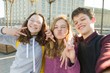© Valerii Honcharuk - Portrait of friends teen boy and two girls smiling, making funny faces, showing victory sign in the street.