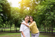 © gballgiggs - Portrait of middle aged asian female with daughter standing and hugging together outdoor,Happy and smiling,Positive thinking,Take care and support concept