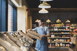 © ReeldealHD images - Small business owner of a food market stocking shelves
