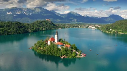 Wall Mural - Lake Bled, Slovenia - 4K aerial footage of flying around Pilgrimage Church of the Assumption of Maria above Lake Bled (Blejsko Jezero) on a beautiful summer day with blue sky and clouds