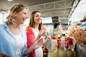 Woman buying fruits and vegetables at local food market.