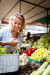 © NDABCREATIVITY - Picture of woman at marketplace buying vegetables