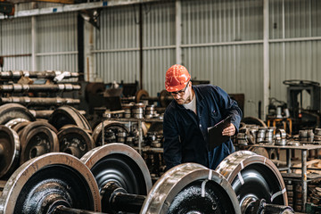 Man working at train factory, quality control check.