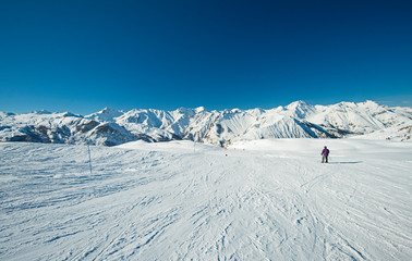 Skiers on a piste in alpine ski resort