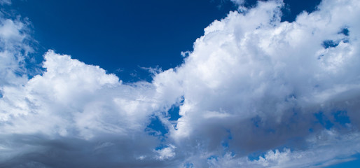 White cumulus clouds on a blue sky, background and texture.