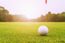 Golf Ball On Green Grass With Sunrise