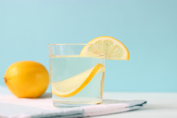 water with lemon on a colored background