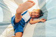 © iuricazac - Happy little boy playing and lying on the blanket outside. Cheerful child enjoying summer day in the park. Handsome kid laughing and having fun on sunlight outdoors. Happy childhood.
