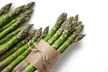 An edible, raw stems of asparagus isolated on white background.