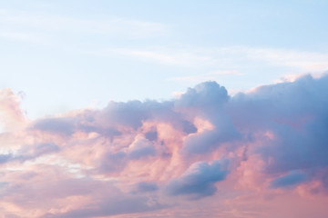  A dramatic cloud of blue, orange and pink on the blue sky in the form of a cat.