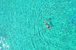 © Daniel CHETRONI - Father and son snorkels through tropical, turquoise waters, aerial view