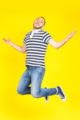 Poster - Jumping young man on yellow background