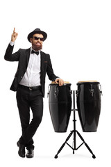 Sticker - Male musician in a suit posing next to conga drums and pointing up