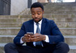 © SB Arts Media - Young business entrepreneur man sitting outdoors urban stairs working and using smart phone