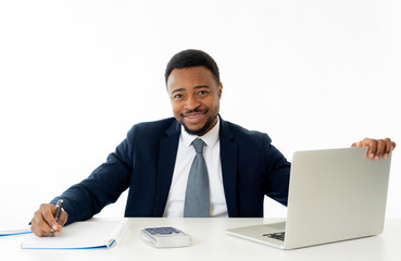 Attractive happy handsome african american businessman working on laptop computer on desk at office