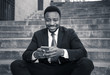 © SB Arts Media - Young business entrepreneur man sitting outdoors urban stairs working and using smart phone